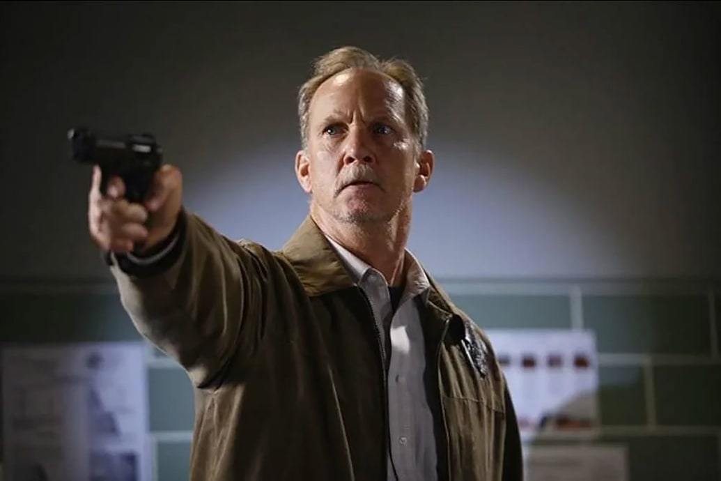 A man holds a gun in a still from 'Grey's Anatomy'