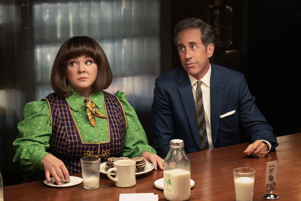 Melissa McCarthy and Jerry Seinfeld at a table in a still from ‘Unfrosted’