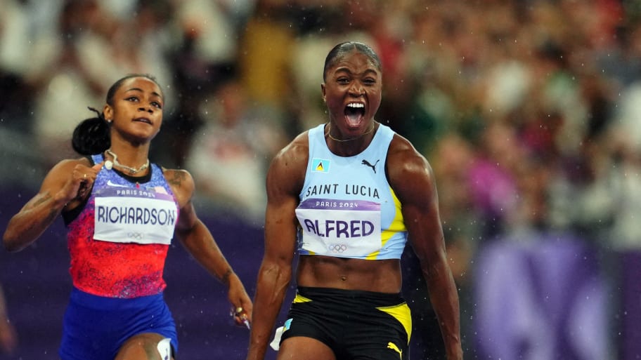 Julien Alfred celebrates as she crosses the line ahead of Sha'Carri Richardson 