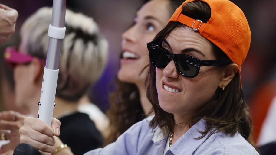 Aubrey Plaza holds a crutch aloft during the 2024 WNBA All Star Game in Phoenix, Arizona.