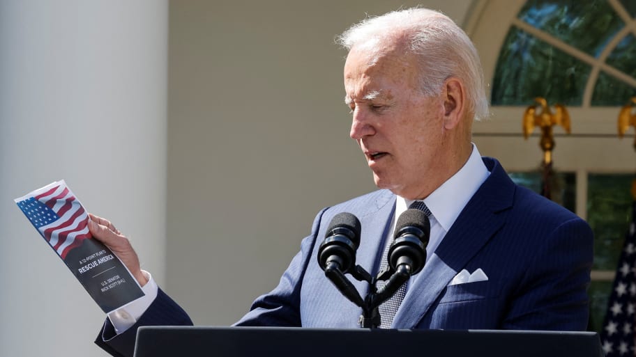 President Joe Biden holds U.S. Senator Rick Scott's (R-FL) \"12-point plan to Rescue America,\" as he speaks at an event on health care costs, Medicare and Social Security, in the Rose Garden at the White House. 