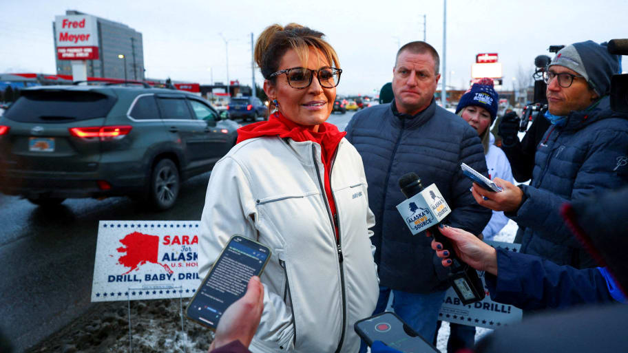 Sarah Palin talks with reporters near the corner of Seward Highway and Northern Lights Boulevard