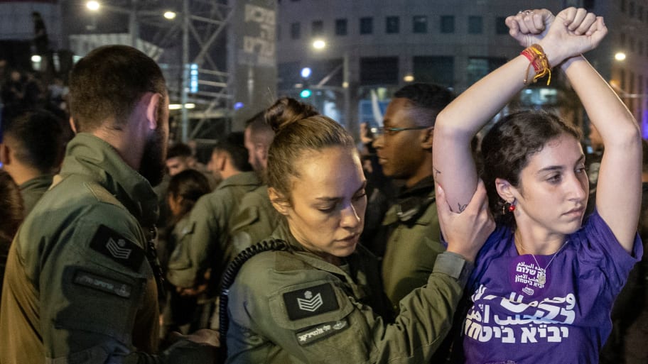 A demonstrator is detained by a member of security forces during a protest against Israeli Prime Minister Benjamin Netanyahu's government and to call for the release of hostages kidnapped in the deadly October 7 attack in Tel Aviv, Israel, June 1, 2024. 