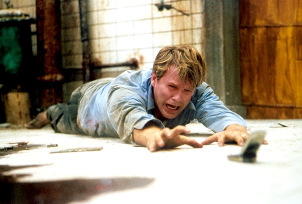 Cary Elwes reaching for a phone in a still from Saw
