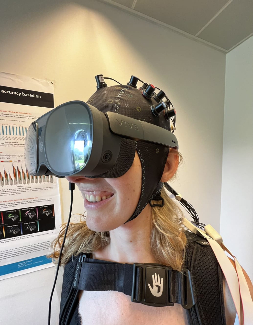 A test subject wears the VR headset with the fNIRS scanner.
