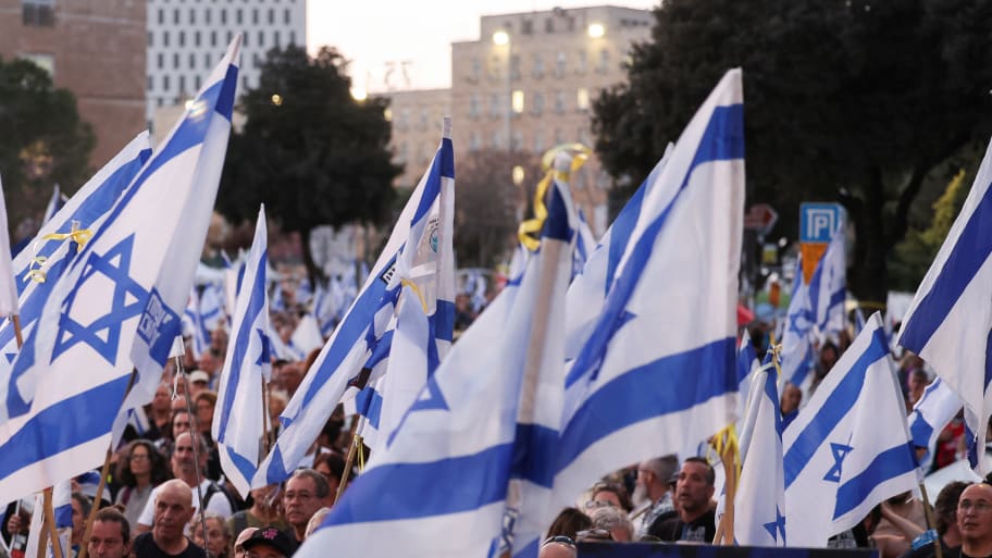 Israeli protesters wave dozens of Israel flags.