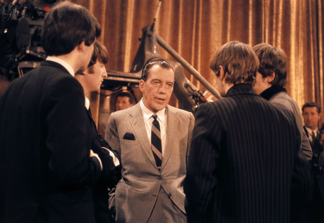 A photo of Ed Sullivan talking to the Beatles.