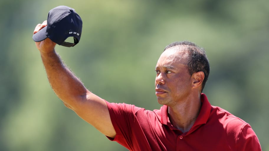 Tiger Woods of the United States waves his hat to the crowd while walking to the 18th green during the final round of the 2024 Masters Tournament at Augusta National Golf Club on April 14, 2024