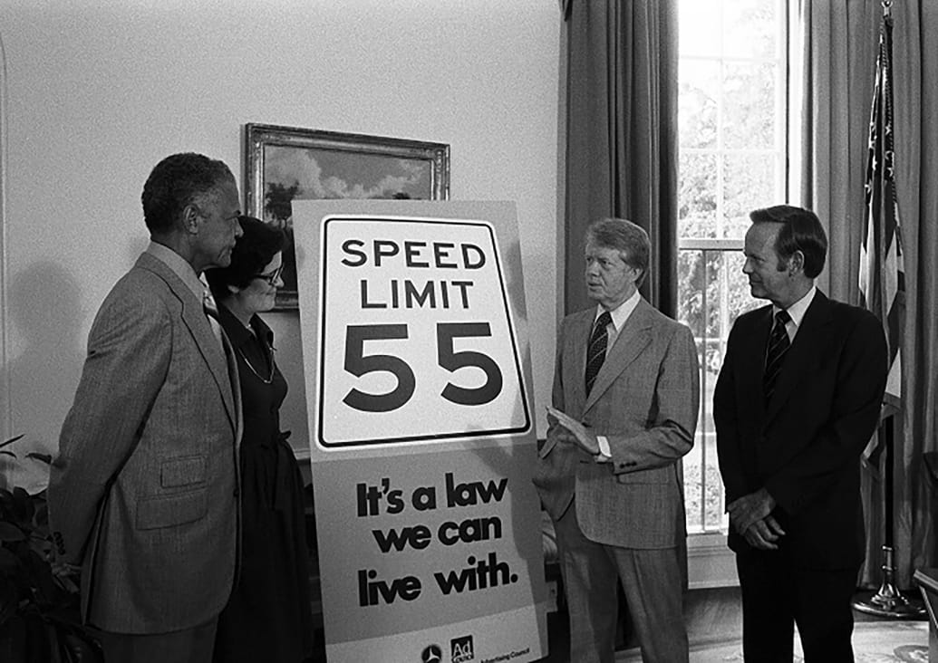 A picture of Ben Davis in the Oval Office with Jimmy Carter as they unveil a speed limit sign.