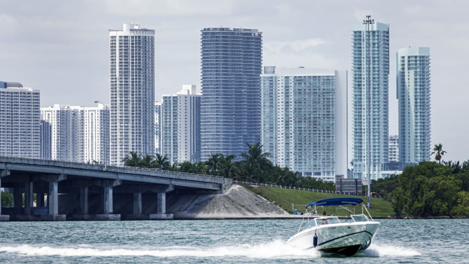Miami Beach, Florida, Biscayne Bay water, Edgewater Midtown high rise skyline with Julia Tuttle Causeway Bridge with speed boat.