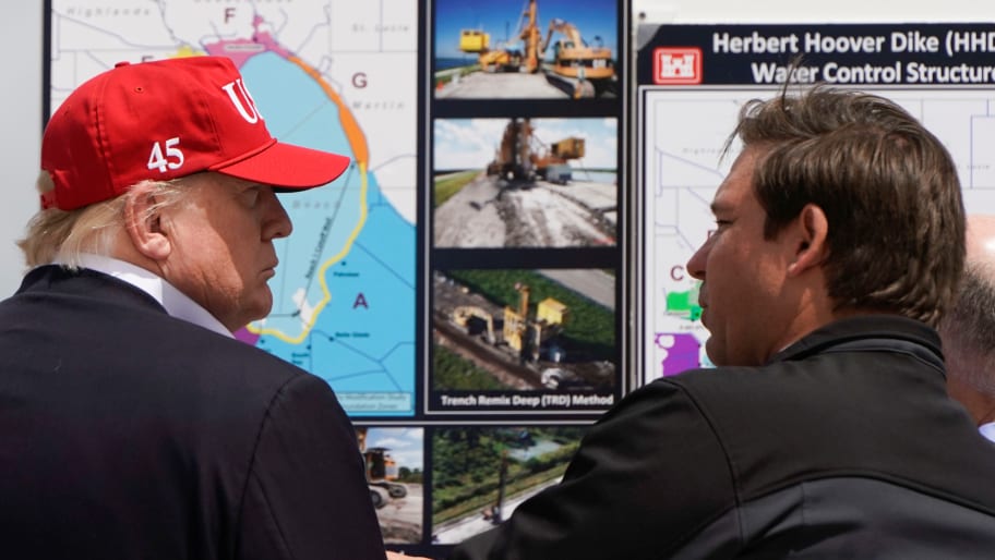 Donald Trump talks with Florida Governor Ron DeSantis during a visit to Lake Okechobee and the Herbert Hoover Dike in Canal Point, Florida.