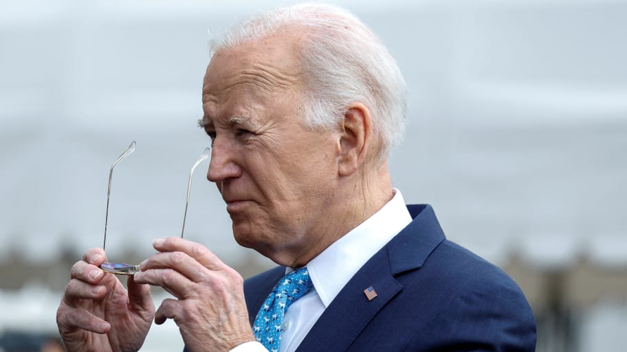 Joe Biden holds his glasses while fielding questions from reporters.