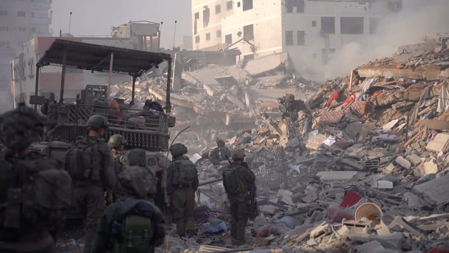 Israeli soldiers operate in Gaza amid the rubble.