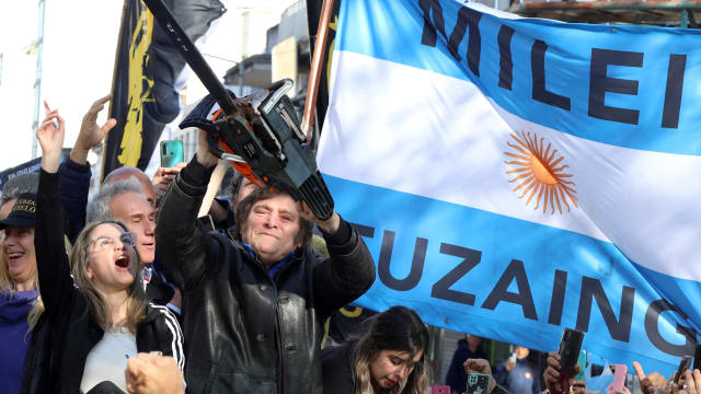 Argentine presidential candidate Javier Milei holds a chainsaw next to Carolina Piparo, candidate for governor of the province of Buenos Aires, during a campaign rally, in Buenos Aires, Argentina, Sept. 25, 2023. 