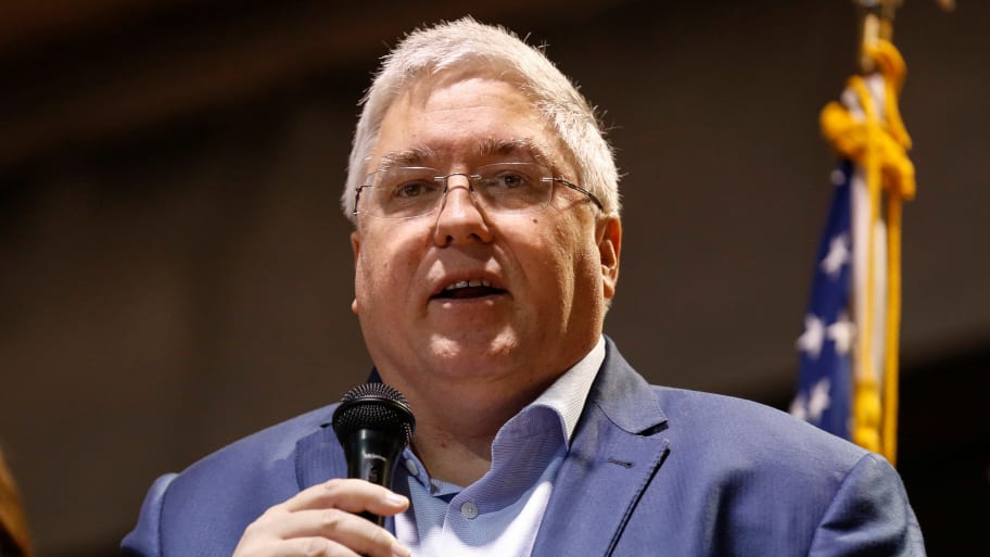 Patrick Morrisey holds a microphone with his mouth open