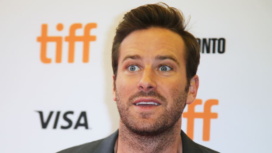 Armie Hammer smiles on a red carpet.