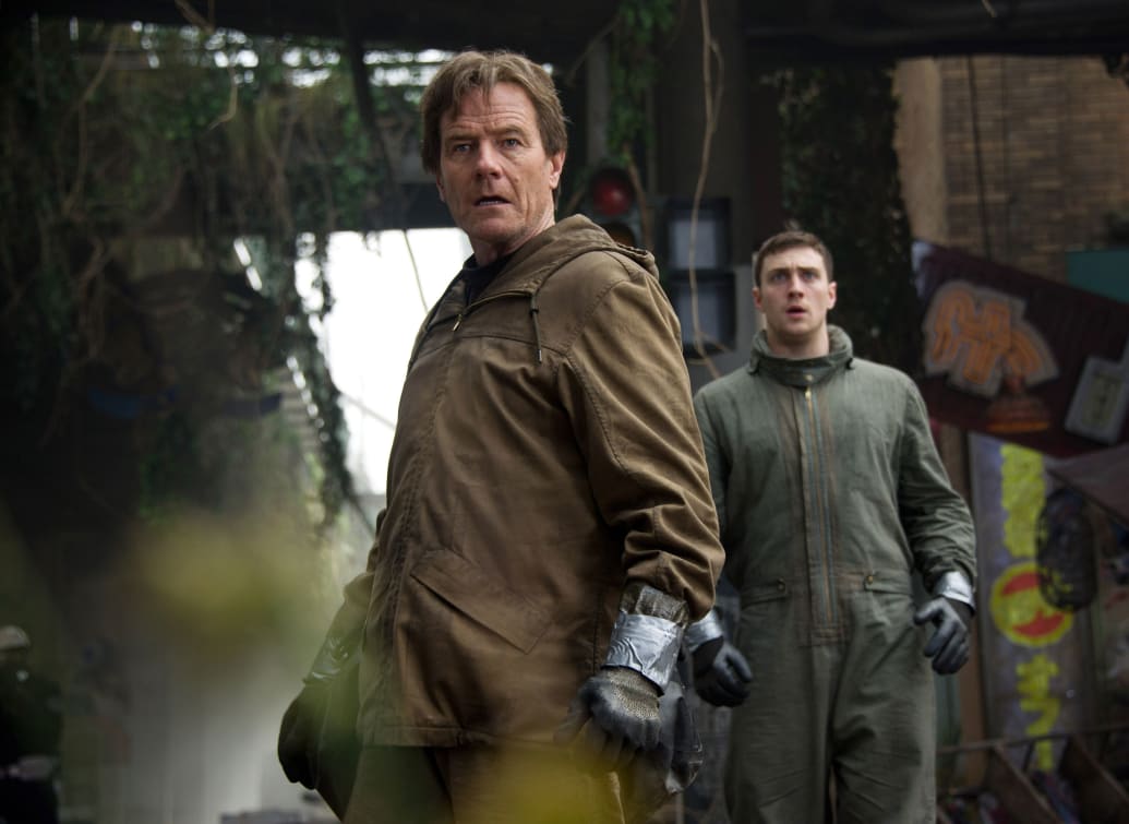 Bryan Cranston and Aaron Taylor-Johnson stand in a still from ‘Godzilla’