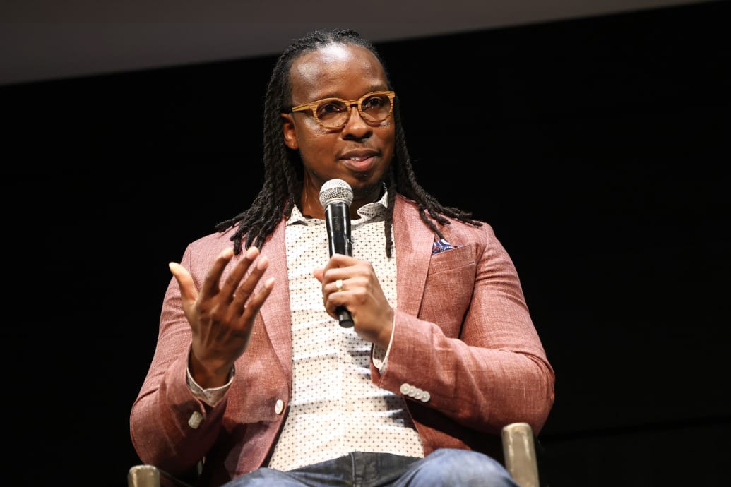 A photograph of Ibram X. Kendi speaking on stage at an event.