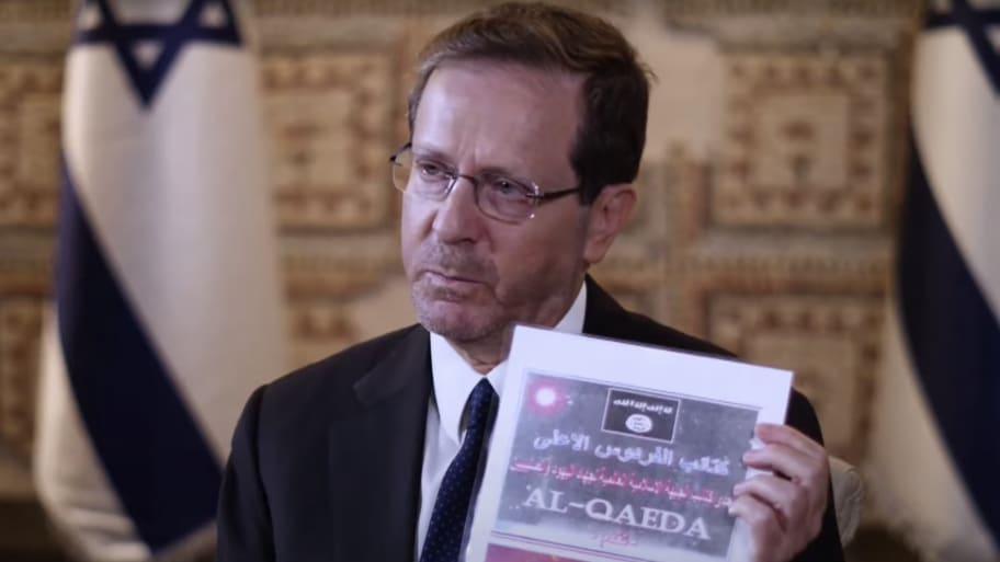 Israeli President Isaac Herzog shows an al Qaeda manual for making chemical weapons allegedly discovered on a USB drive carried by a Hamas fighter.