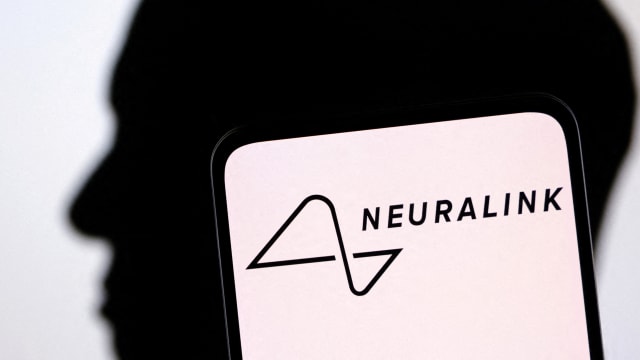 The Neuralink logo is displayed on a phone with a silhouette of Elon Musk in the background.