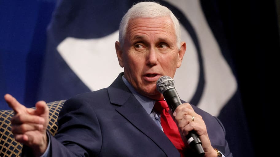 Mike Pence points his right hand as he holds a microphone.