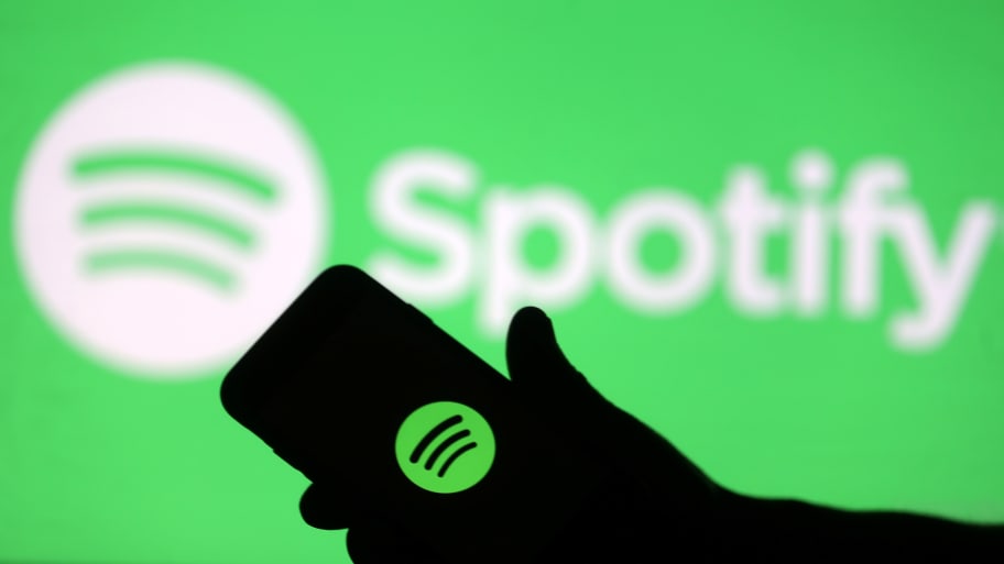 A smartphone is seen in front of a screen projection of Spotify logo, in this picture illustration taken April 1, 2018. 