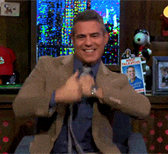 Gif of Andy Cohen doing a happy dance with thumbs up