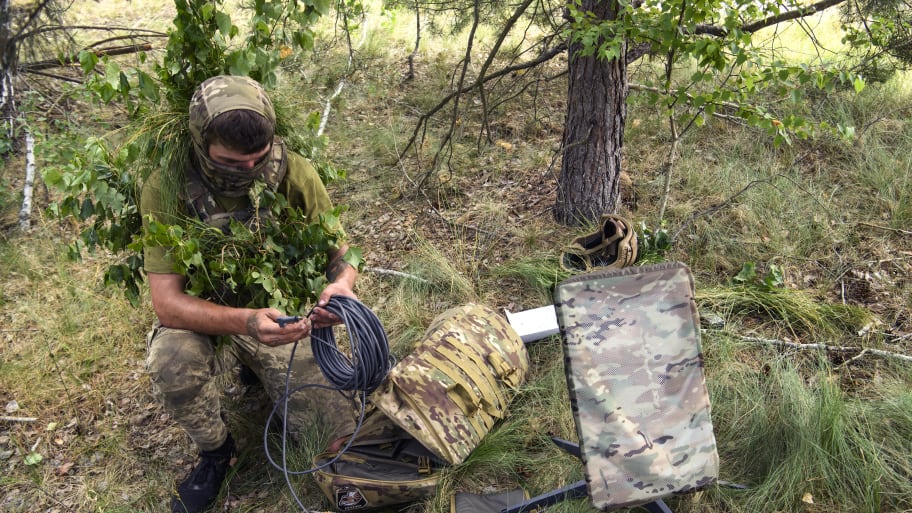 A Ukrainian soldier uses the Starlink system during military exercises in the Chernihiv region, Ukraine