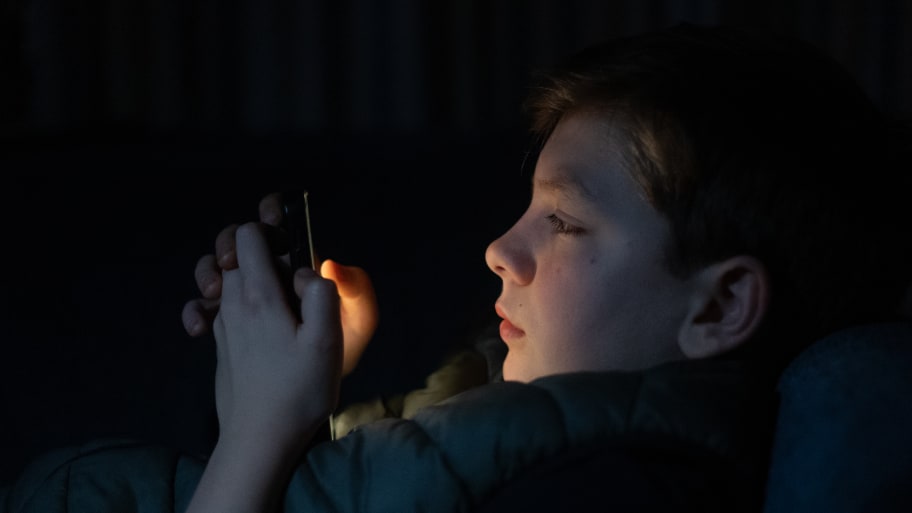 A 12-year-old boy looks at a smartphone screen on March 10, 2024 in Bath, England.