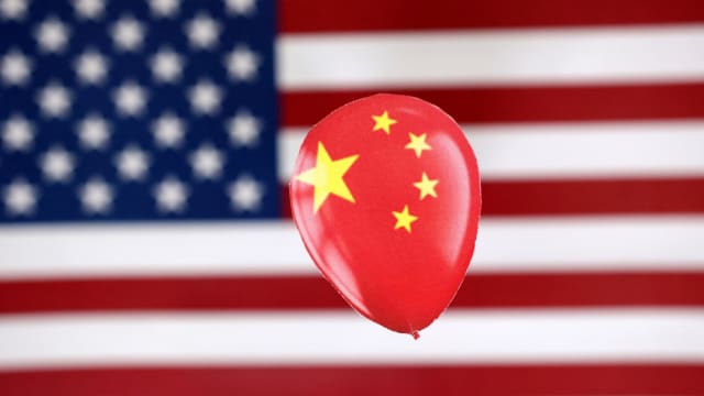 A printed balloon with Chinese flag is placed on a U.S. flag.