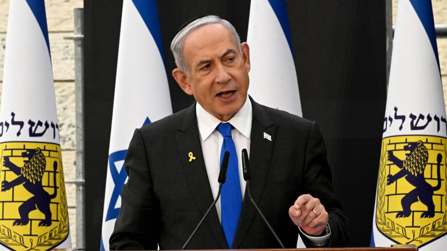Israeli Prime Minister Benjamin Netanyahu gives a speech before flags.