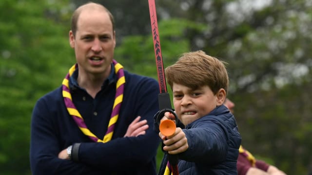 Britain's Prince George of Wales tries his hand at archery as Britain's Prince William, Prince of Wales, watches him, while taking part in the Big Help Out, during a visit to the 3rd Upton Scouts Hut in Slough, west of London, Britain, May 8, 2023.