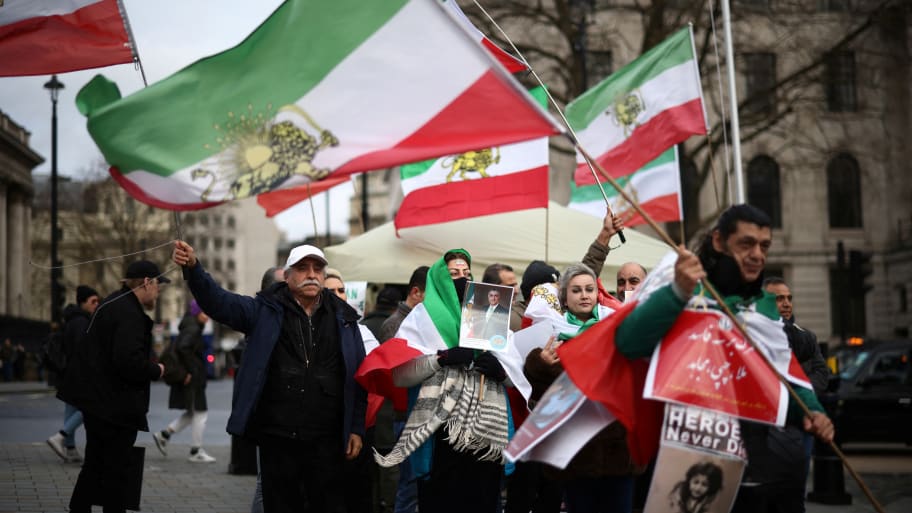 People holding Iranian flags protest against the government.
