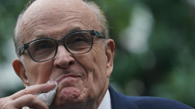 A photo of Rudy Giuliani wiping his mouth.
