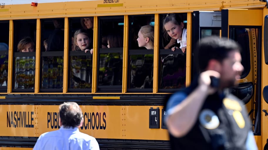 Students look out a bus window after a mass shooting in Tennessee