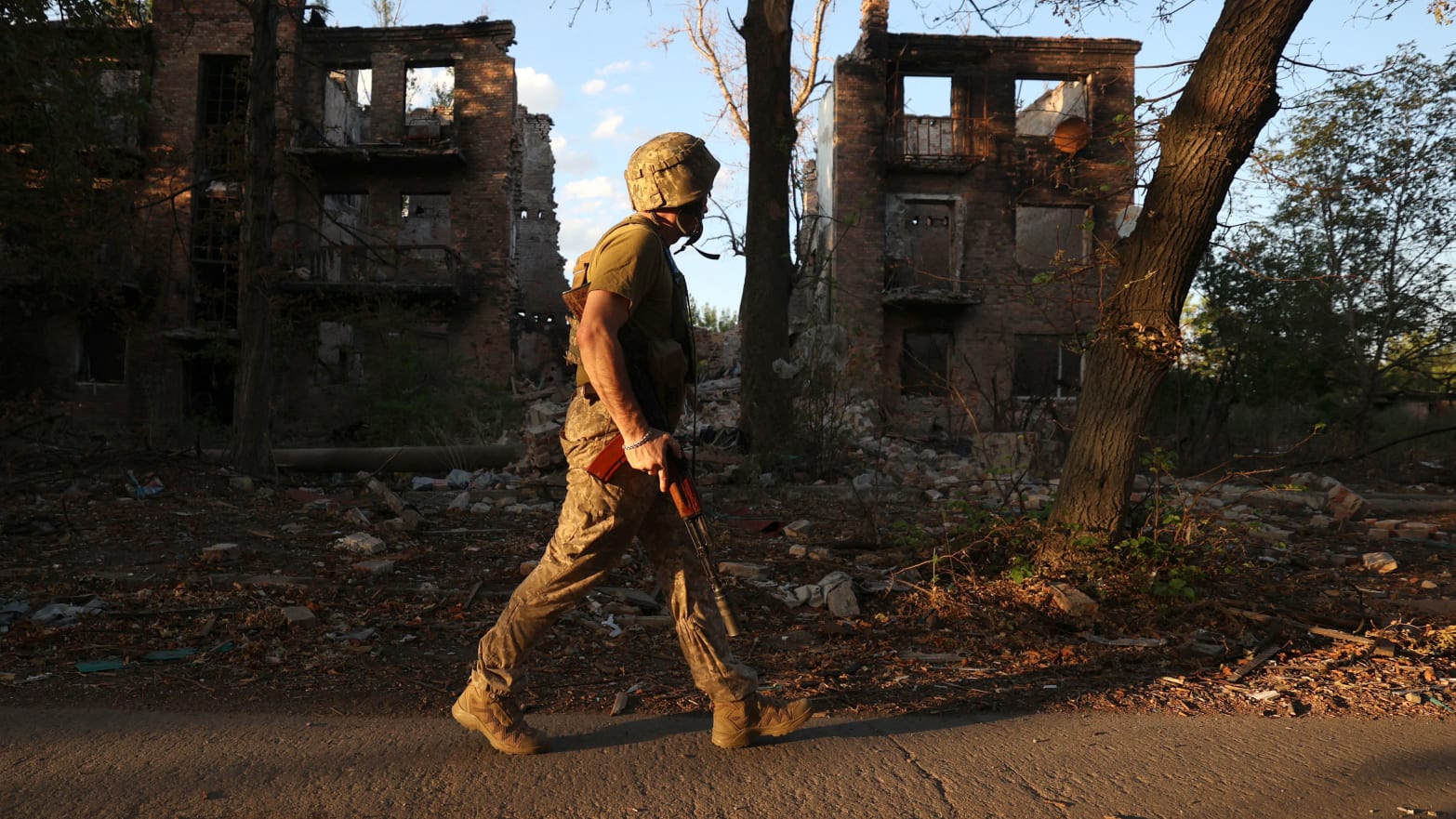 A Ukrainian serviceman of the 225th Separate Assault Battalion patrols as he walks past an apartment building destroyed by an airstrike in the town of Chasiv Yar, Donetsk region, on July 24, 2024, amid the Russian invasion of Ukraine. 