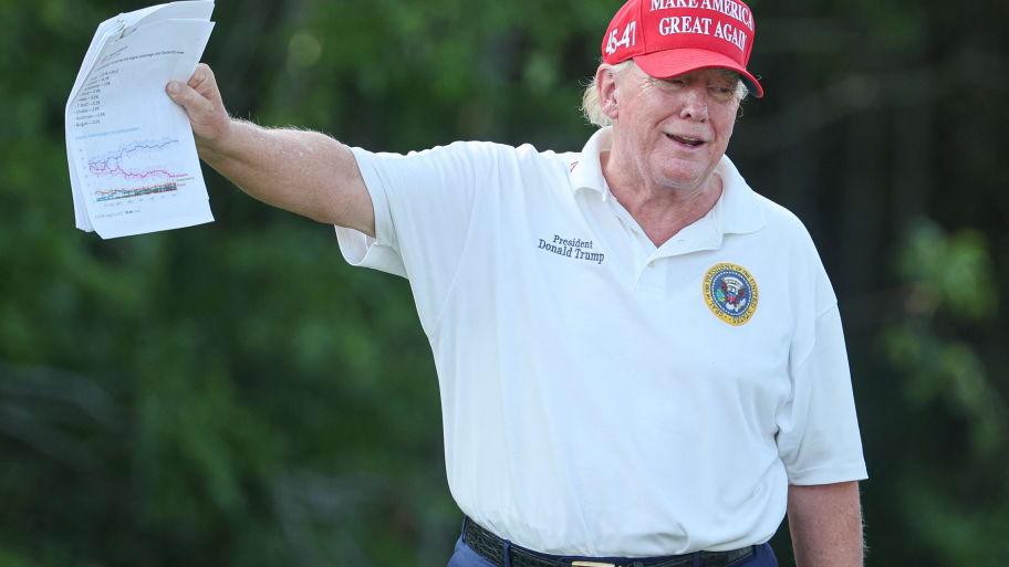 A picture of Donald Trump showing printouts of political polls to reporters during a golf tournament at his club in New Jersey.