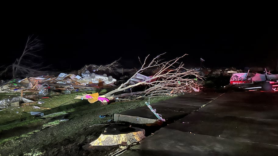 A fallen tree and debris in the aftermath of the Mississippi tornado.