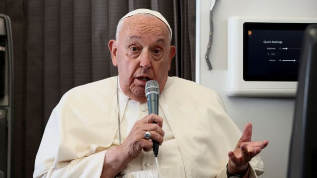 Pope Francis delivering a press conference aboard the papal plane.