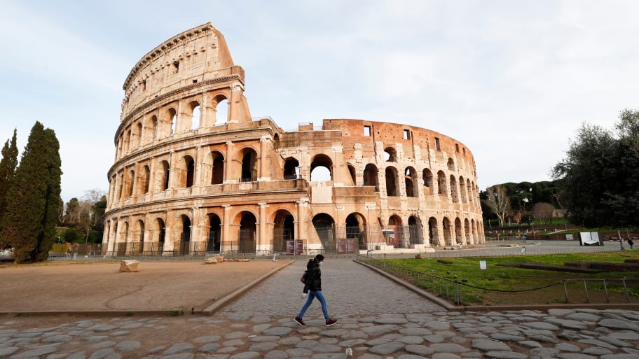 A person walks by the Coliseum in Rome, Italy.