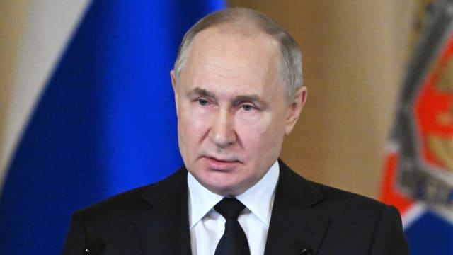 Russian President Vladimir Putin speaks at a podium.