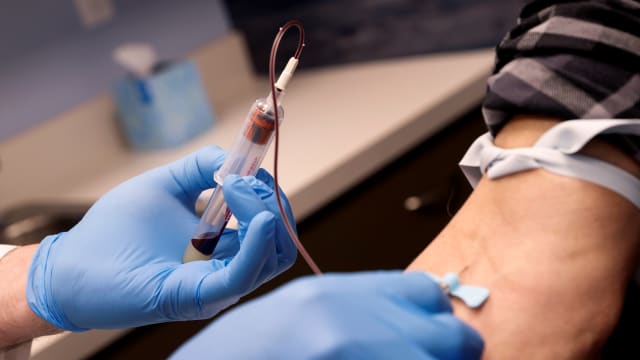 A blood test being conducted with a vial to receive blood 