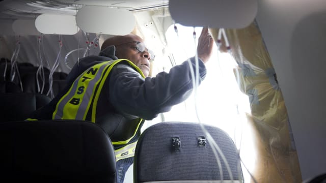 National Transportation Safety Board (NTSB) investigator-in-charge John Lovell examines the fuselage plug area of Alaska Airlines Flight 1282 Boeing 737-9 MAX in Portland, Oregon, Jan. 7, 2024.