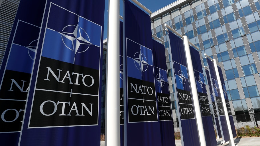 Banners displaying the NATO logo are placed at the entrance of new NATO headquarters during the move to the new building, in Brussels, Belgium