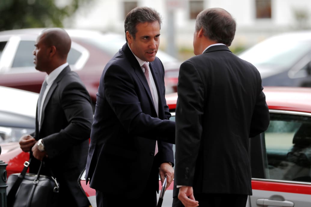 Michael Cohen exits a vehicle while speaking with U.S. Capitol staff.
