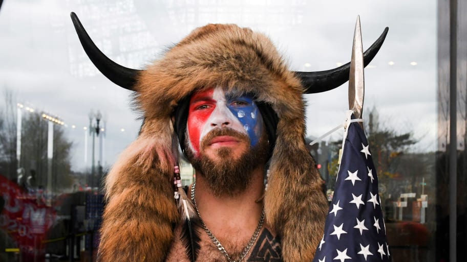 Jacob Chansley, "QAnon Shaman," dons face paint, a spear, and a headpiece