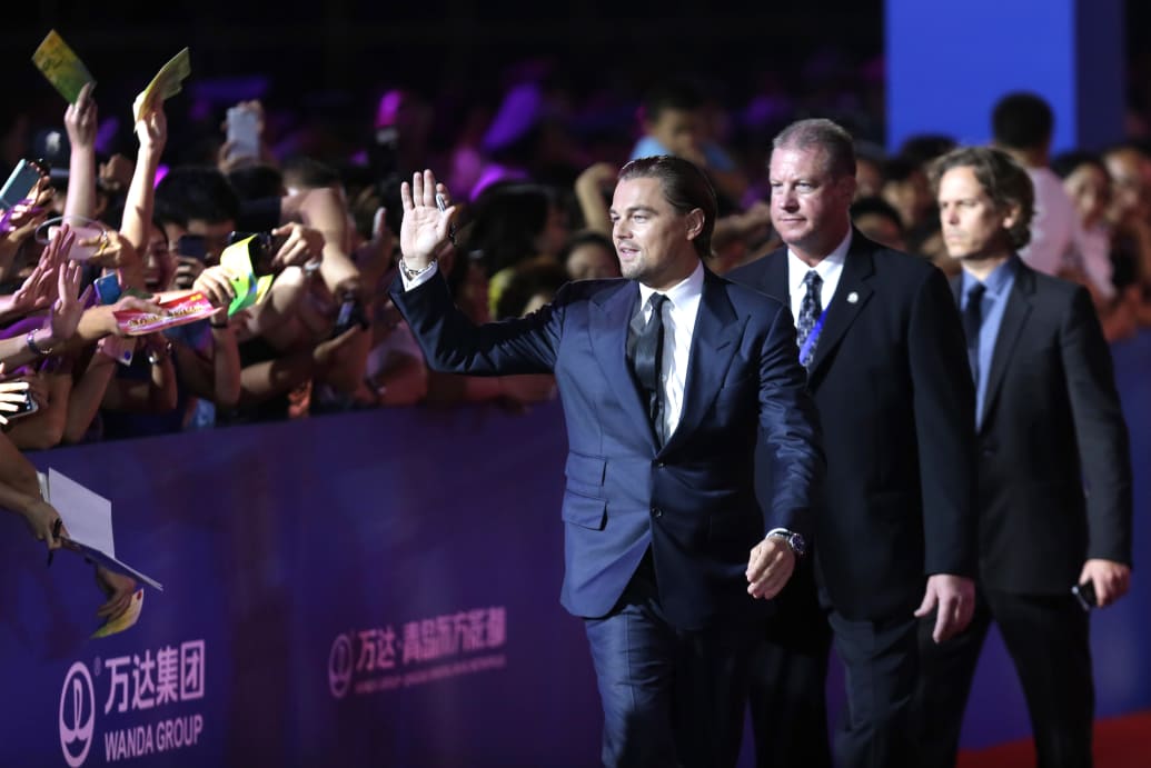 Leonardo DiCaprio waves to fans during a red carpet event promoting Wanda Group's Oriental Movie Metropolis project in Qingdao.
