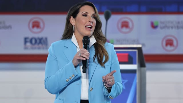 Ronna McDaniel holds a microphone as she speaks on stage before a Republican presidential primary debate.