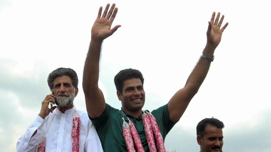 Arshad Nadeem, Pakistan's first Olympic gold medalist athlete in the men's javelin, waves to people who gather to welcome him at his hometown in Mian Channu, Pakistan August 11, 2024. 