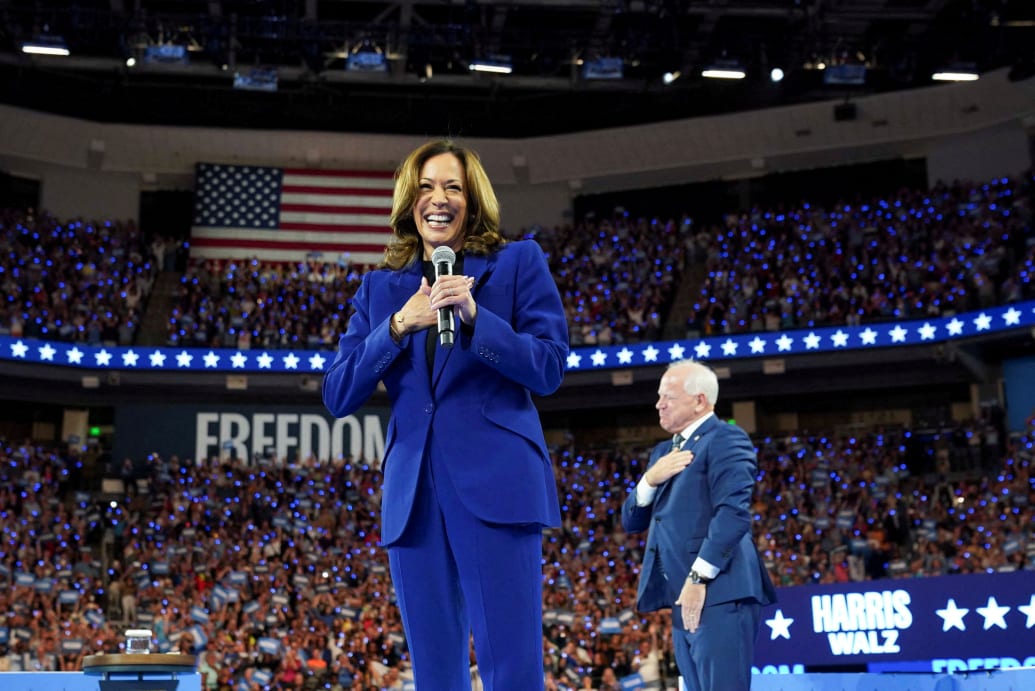 Kamala Harris reacts while her running mate, Minnesota Governor Tim Walz, stands nearby during a rally in Milwaukee, Wisconsin on August 20, 2024.